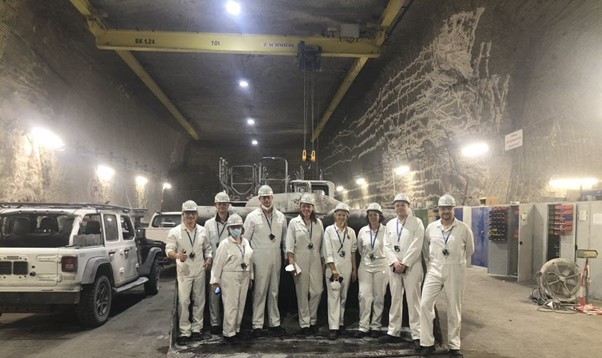 Das Foto zeigt das Team des Bootcamps der SAP Fiori Makers. K+S- und SAP-Mitarbeitenden tragen weiße Arbeitsausrüstung und Helme, während sie in einem der Bergwerkstunnel stehen.