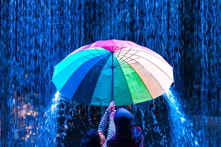 무지개색 우산을 들고 서 있는 아이들