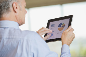 Businessman analyzing pie chart on digital tablet