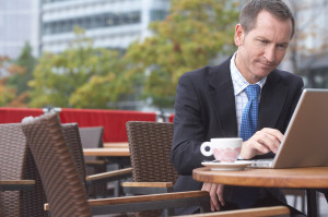 Businessman working on laptop at cafe