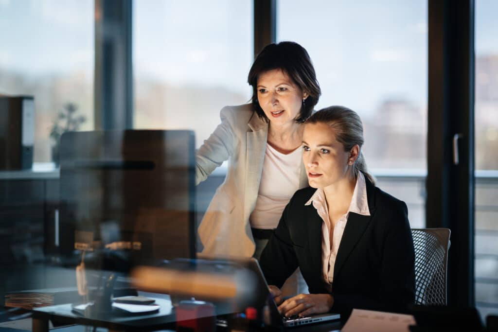 Women look at a computer to illustrate S/4HANA