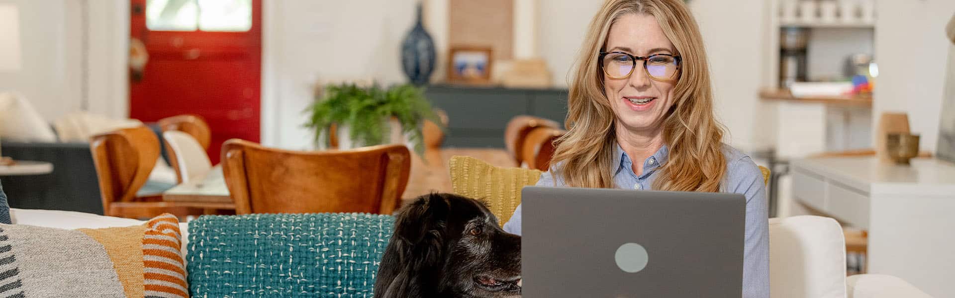 Woman working from home, dog sitting next to her