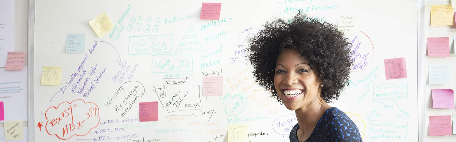 Smiling woman standing in front of whiteboard