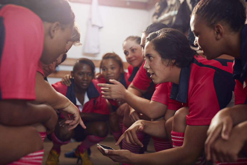 Womens rugby players looking at phone before game