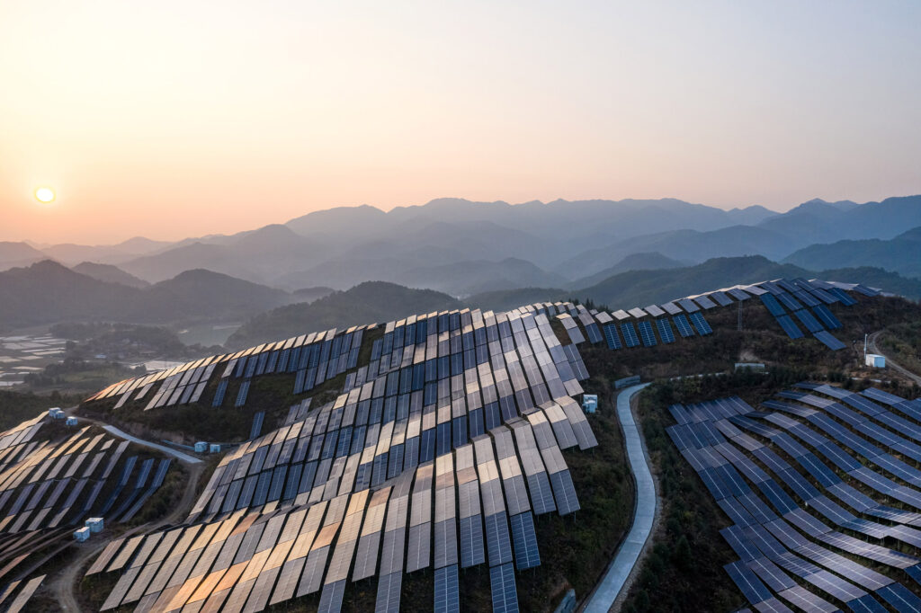 Aerial view of a solar power plant on the top of the mountain at sunset