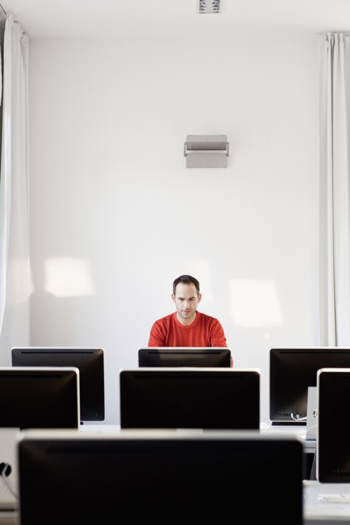 Man sitting at computer in lecture hall