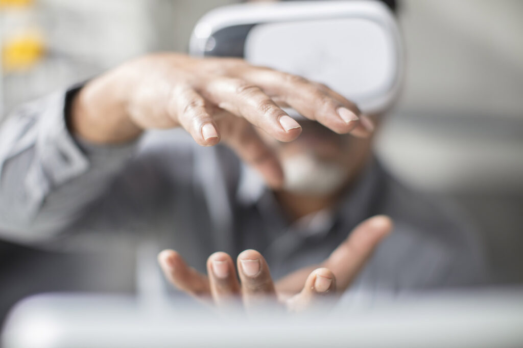 Man shaping with his hands wearing VR glasses in office