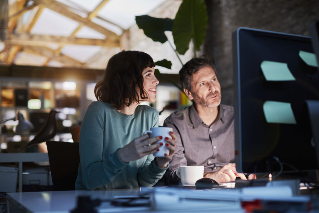 Two coworkers collaborating on computer