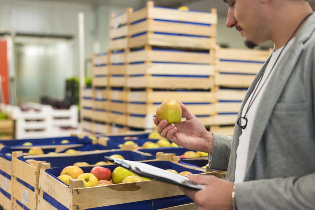 Man checking apples in food bank warehouse